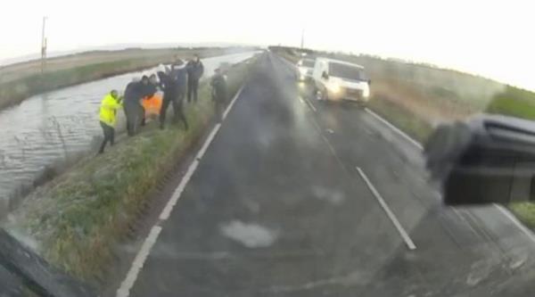 People pulling a man from a ditch